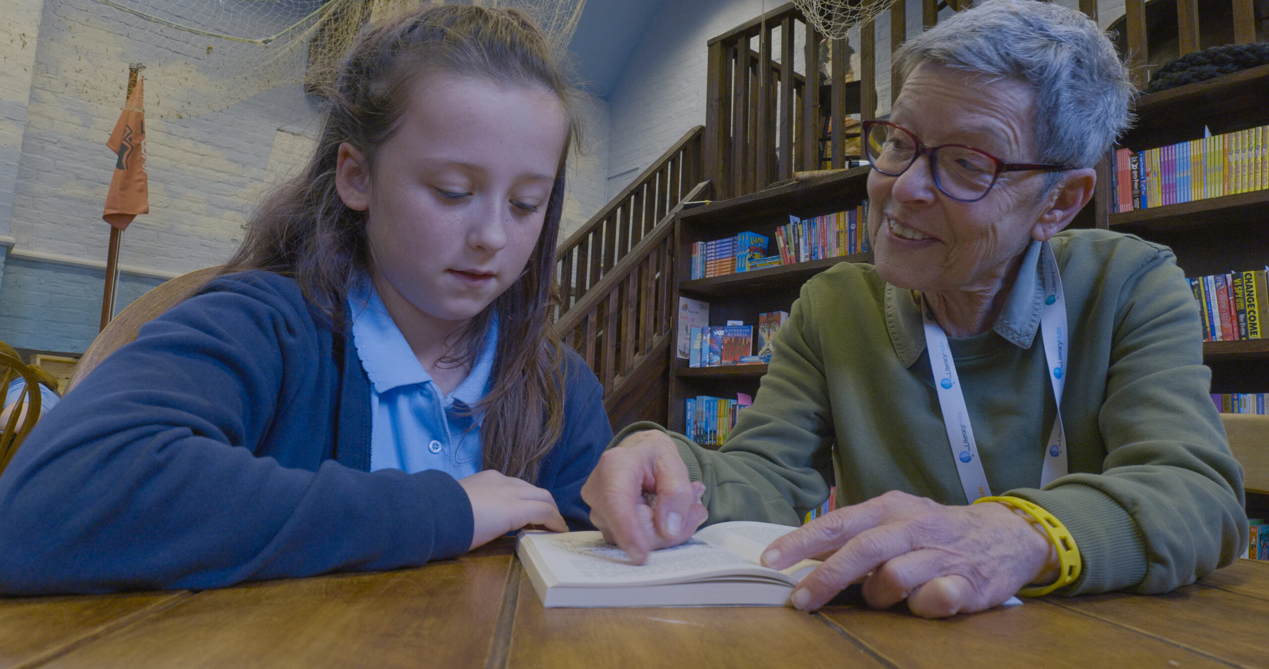 Young girl reads with an older woman